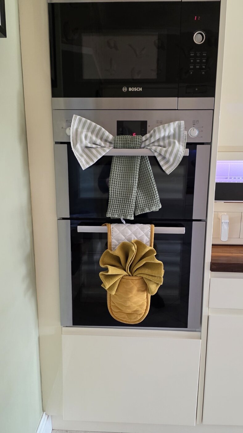 Tea towels folded into decorative bows on oven handles